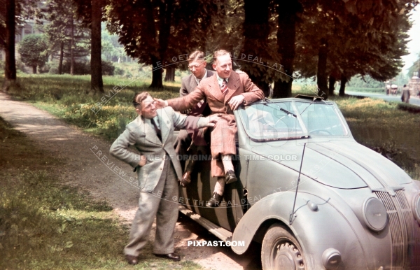 3 young civilian German men sitting on a army feldgrau painted Adler 2.5L Convertible 1937. Germany 1940.