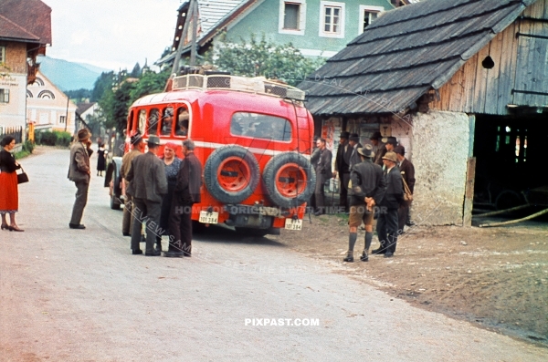 Austrian farmers getting ready to board a red Deutsche Reichspost bus. Austrian village 1939