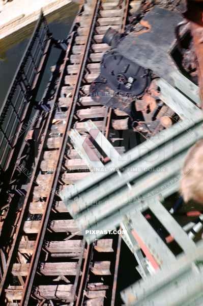 Blown up German train on its side. Under new Bridge transporting American GIs into Worms Germany 1945