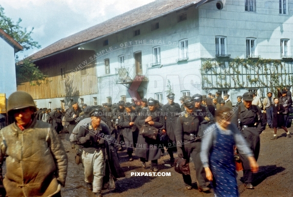 Captured German Luftwaffe soldiers walking through Murnau Bavaria Germany 1945. 101st Cavalry Regiment USA. POW