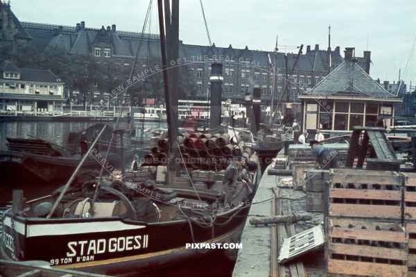 Cargo Steam Barge stad Goes II loaded with steel pipes and beer in front of  Amsterdam Centraal station Netherlands 1940