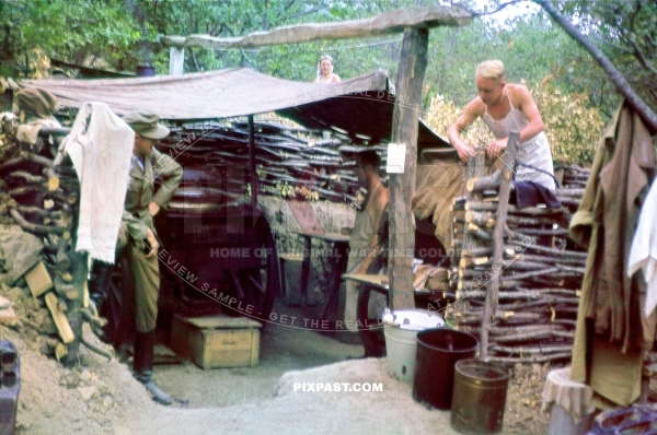 Cook wearing tropical uniform cooking with camouflaged thatch  Gulaskanone. Bunker Ukraine 1942