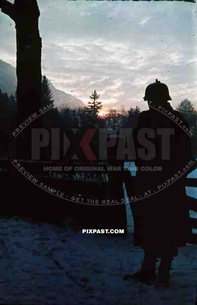 German army soldier in helmet M40 and Kar98 Rifle stand guard in snow field Finland 1944. sunset.