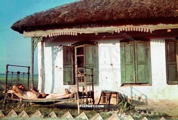 German soldier sleeping on bed outside small cottage. Ukrainian village. Ukraine 1942