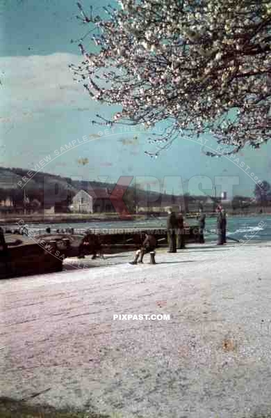 German soldiers watching french fisher men beside Seine river near Paris, France, 1940.