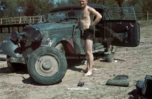 German staff driver changing flat tyre of Mercedes 230, W143. 1941. Russian Front. 4th Panzer Division. IC-131634