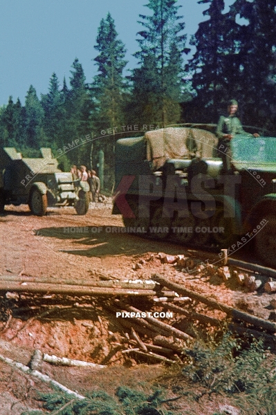 Germany army half track tractor pulling captured Russian armored car IZ ZIS-5 truck out of forest. Russia 1942