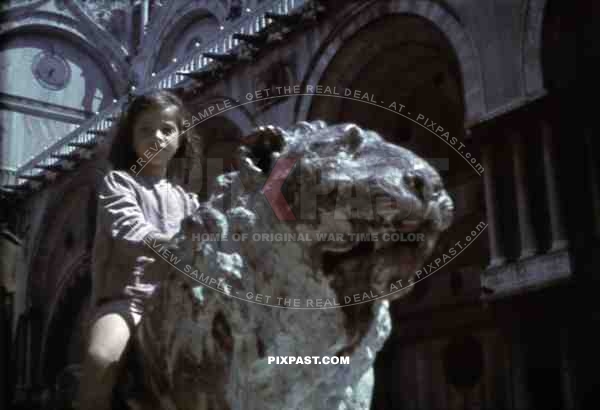 Little girl sitting on lion statue in Venice, Italy 1943