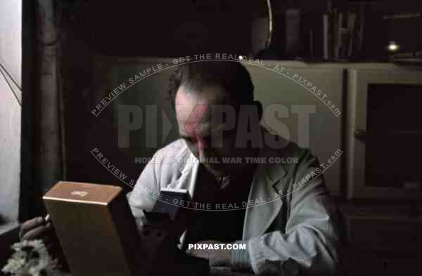 Man using farbdias 35mm slide viewer in apartment in Munich 1941