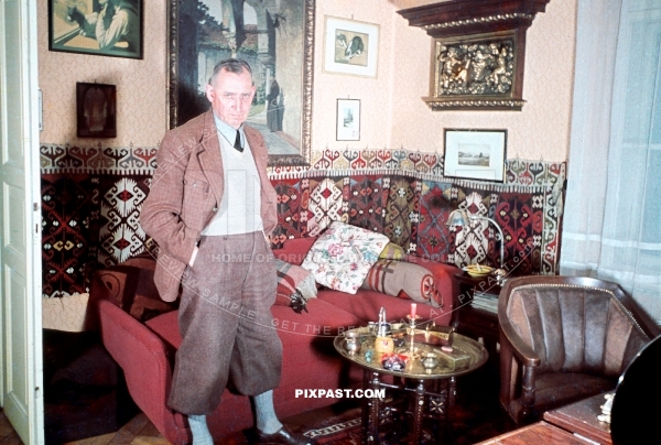 Mein Zimmer bunt 1939. Father of German sailor showing proudly his sitting room. Leather chair, paintings, wall carpet.