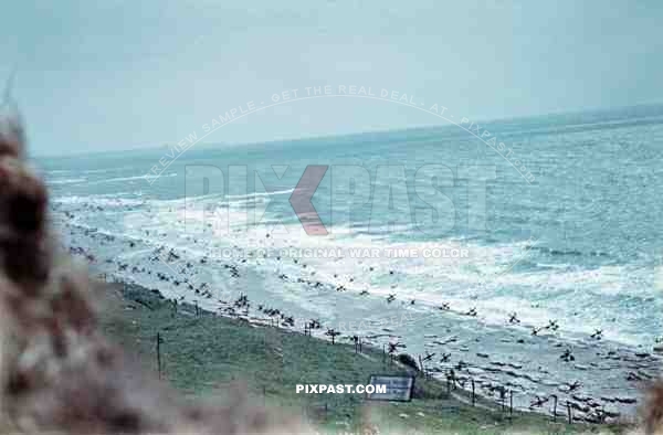 Normandy Coast Beach. France 1944. Days before D-Day Invasion. German steel Hedgehogs and mine fields. MG position.