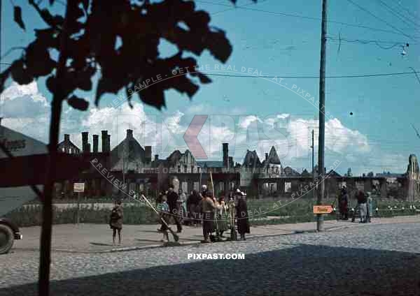 peasents in destroyed russian town bombed buildings road signs Pilviskiai russia 1942