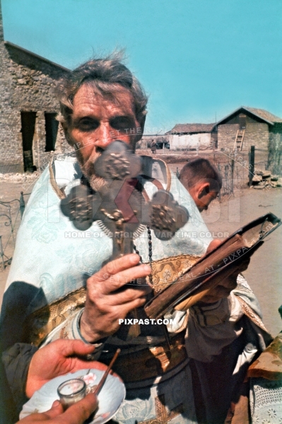 Russian Orthodox Church Priest holding his crucifix and bible in small Village. Ukraine 1942