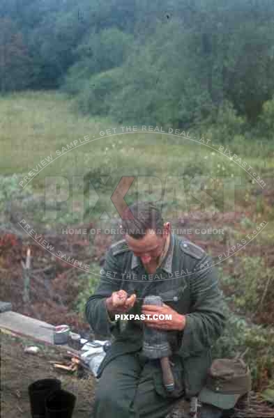 Wehrmacht soldier darning socks at the base between Bryansk (Russia) and Konotop (Ukraine) 1944, handgrenade